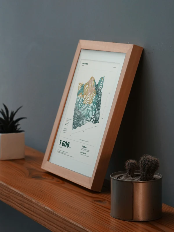 The Katahdin artwork digitally placed in a frame on a shelf beside plants. Framing and proportions are illustrative.